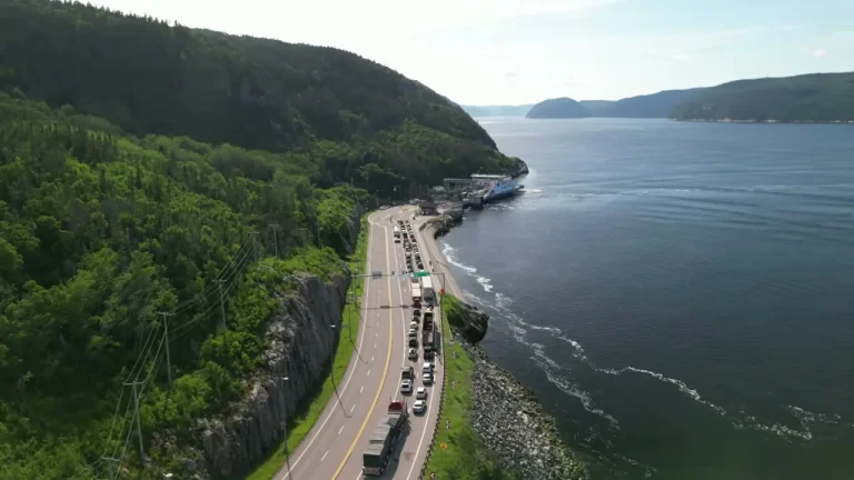La route 138 entre la falaise et le fjord du Saguenay, avec la file pour le traversier de Tadoussac
