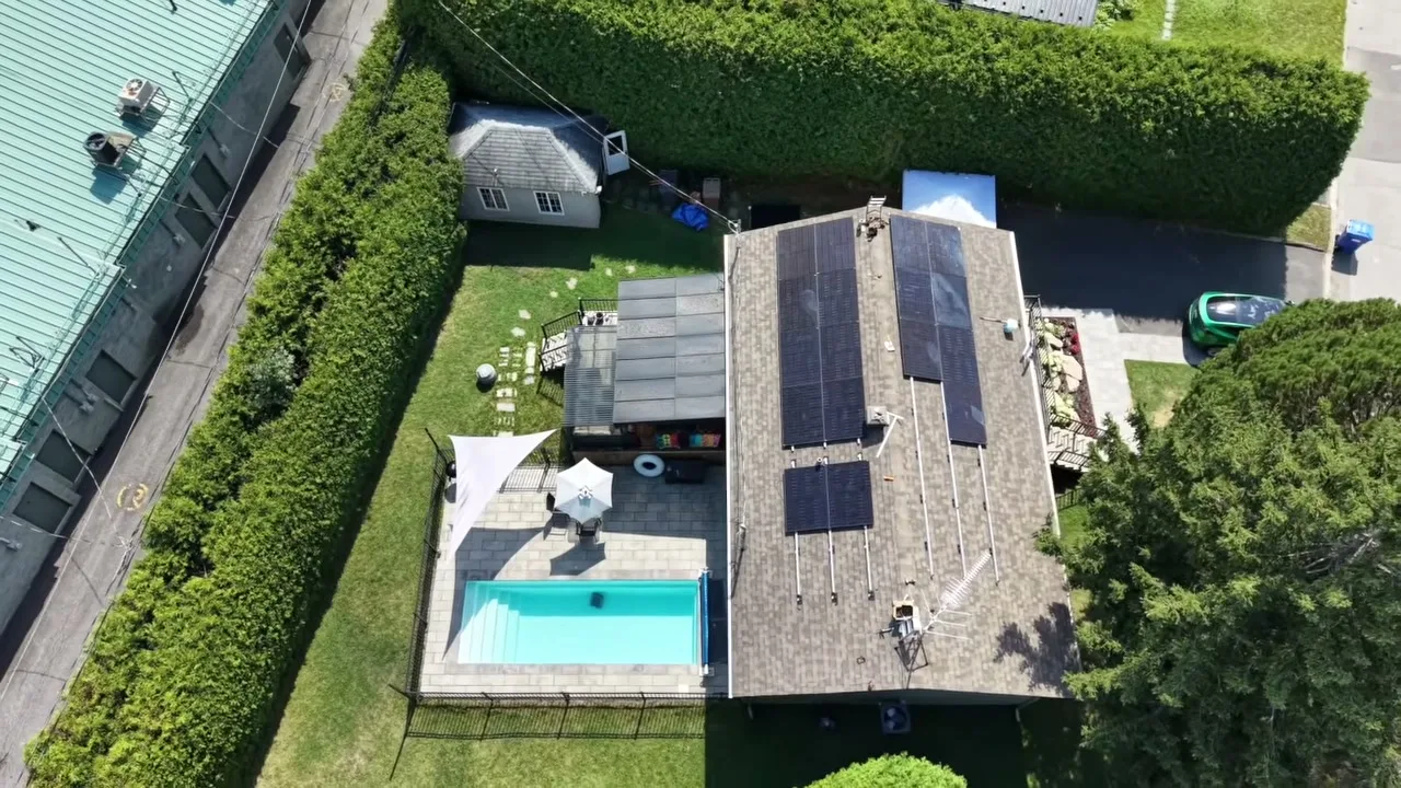 Vue du dessus d'une maison avec 24 panneaux solaires sur le toit avant et arrière